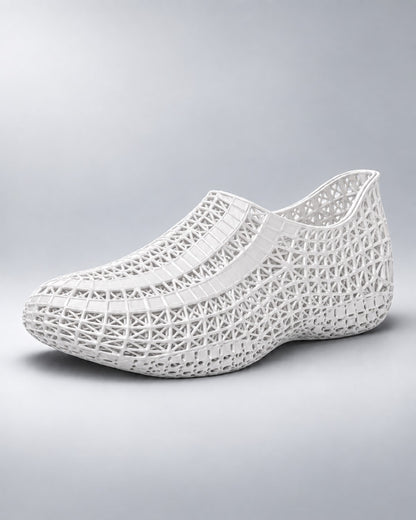 A white slip-on shoe with an intricate, open geometric lattice pattern, shown from a three-quarters angle on a light gray gradient background.