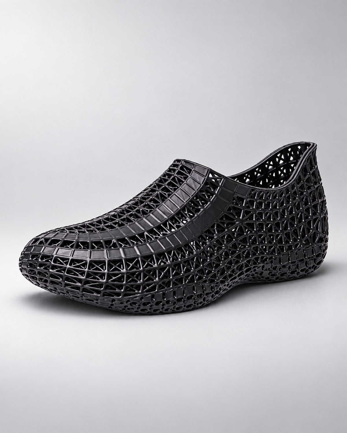 A single slip-on mesh shoe in a taupe brown color, featuring a textured patterned upper and a matching flat sole, shown against a plain white background.