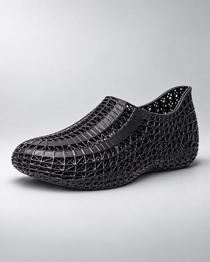 A single slip-on mesh shoe in a taupe brown color, featuring a textured patterned upper and a matching flat sole, shown against a plain white background.