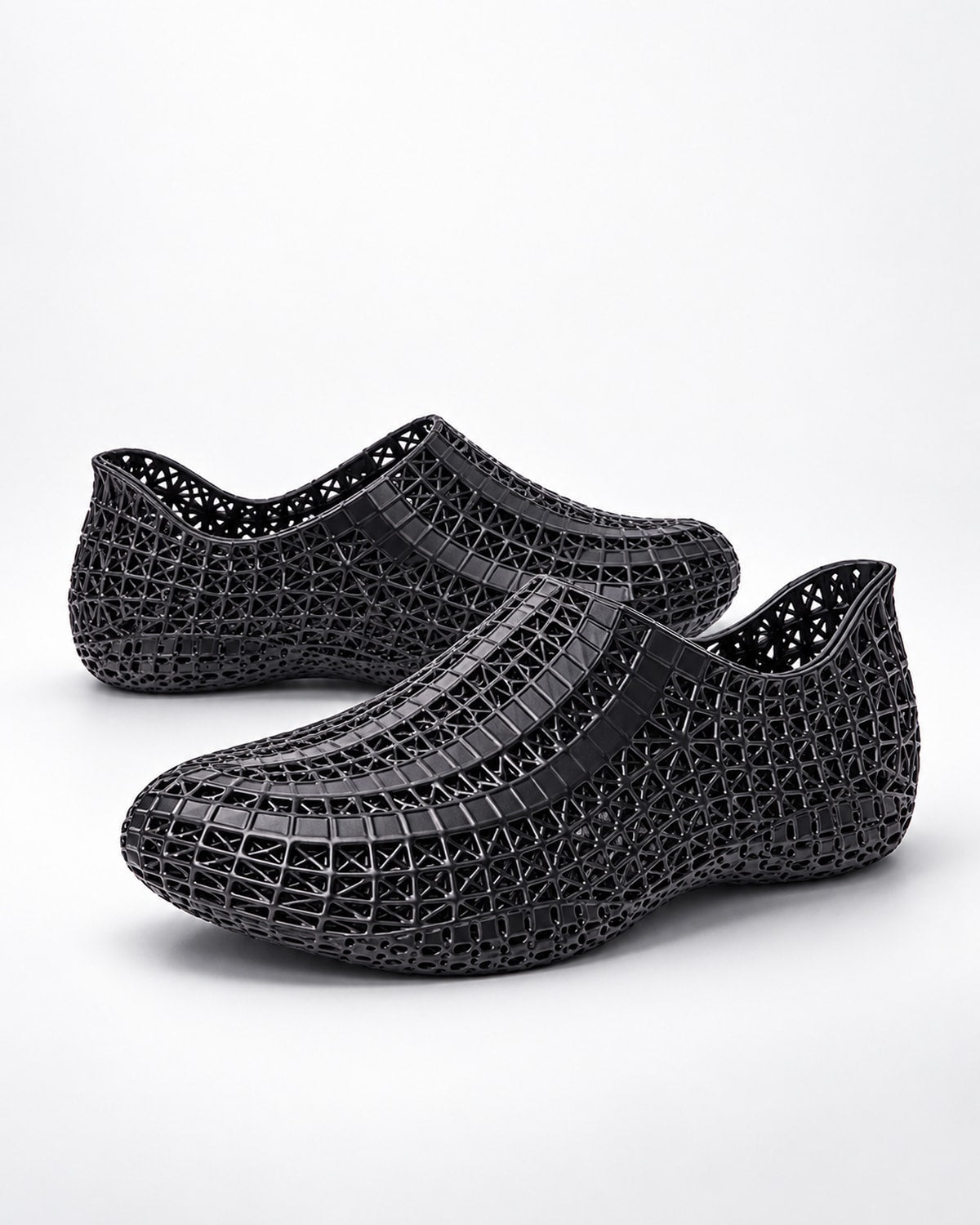 A pair of black mesh slip-on shoes with a textured, woven-like pattern, displayed on a clean white background.