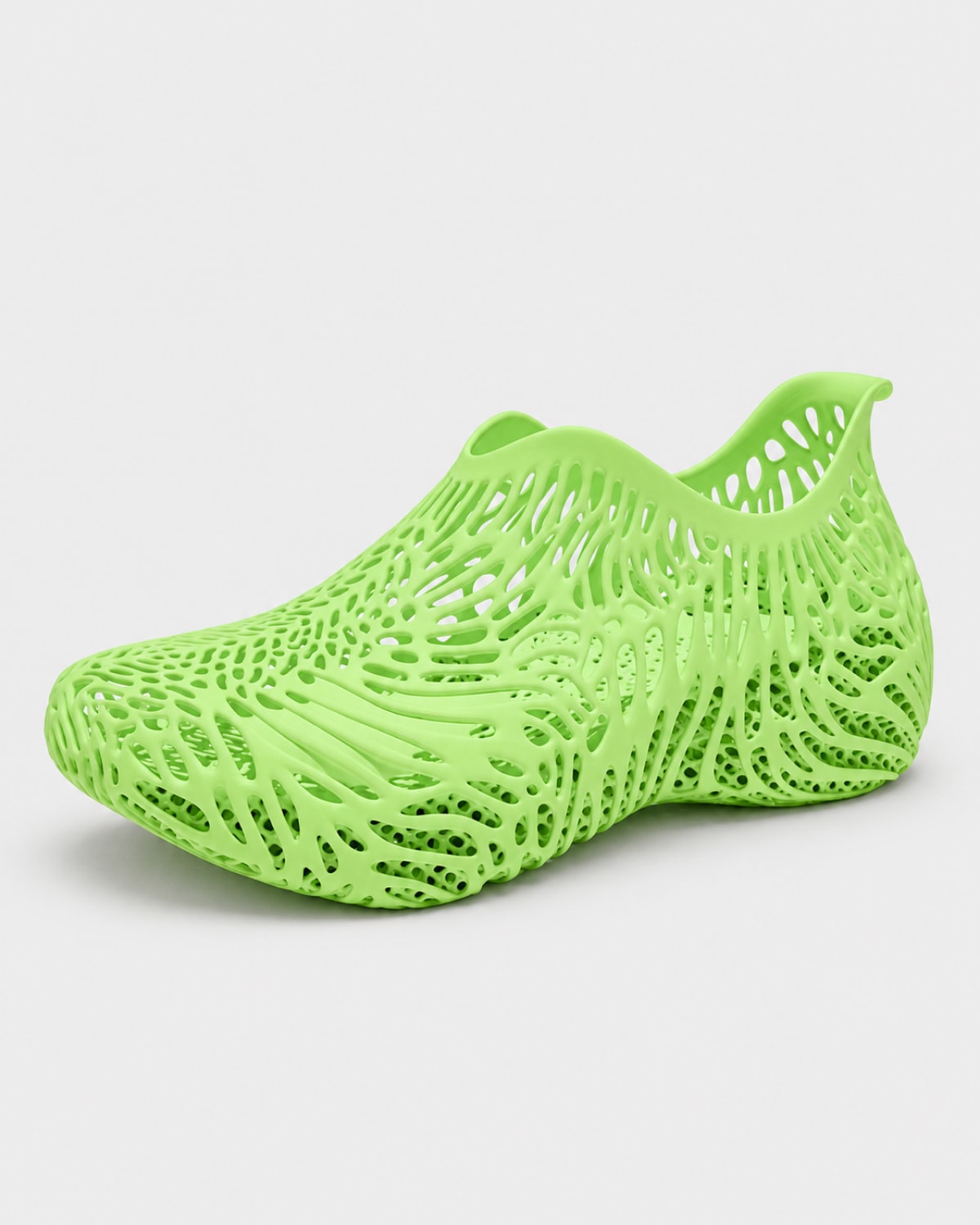 A single bright lime green mesh slip-on shoe with an intricate, openwork lattice pattern, shown on a light gray background.