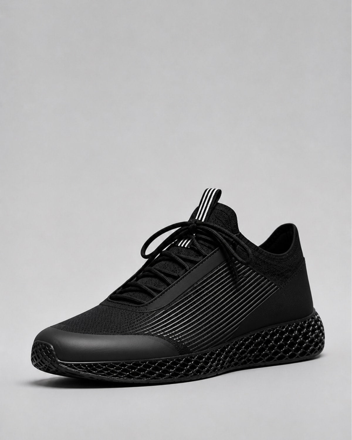 A black athletic sneaker with a textured knit upper, black laces, and a sculpted 3D-printed sole, shown against a neutral gray background.