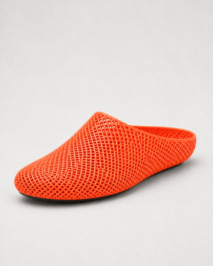 A bright orange mesh slip-on clog shoe with a pointed toe, shown from a three-quarters angle on a light gray background.