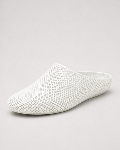 A white open-toe mule slipper with a textured, open-knit mesh upper, shown from a three-quarters angle on a light gray background.